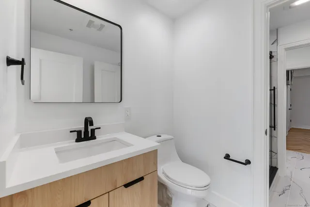 a bathroom with a toilet a sink and mirror