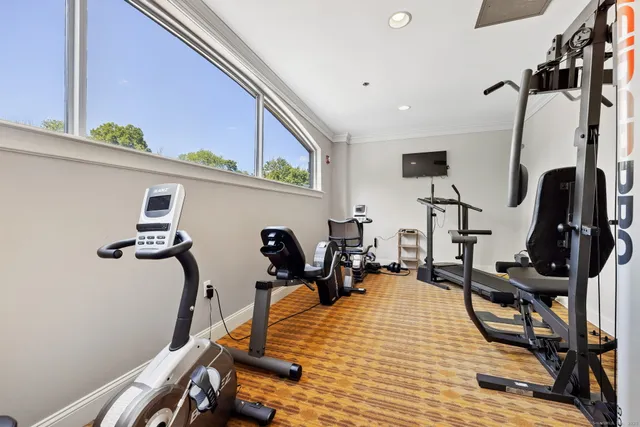 a room with gym equipment and wooden floor