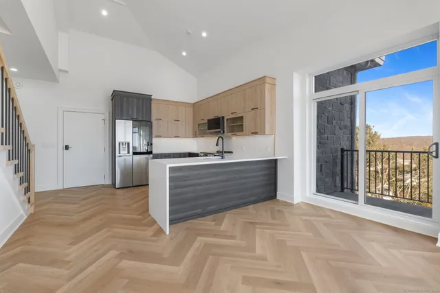 a view of kitchen with stainless steel appliances kitchen island granite countertop cabinets and wooden floor