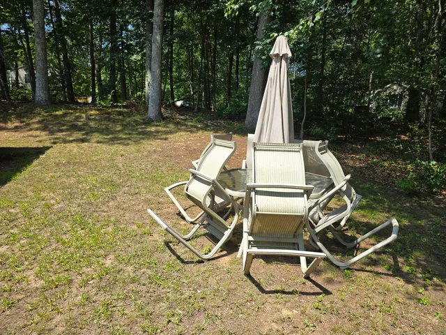 a view of a backyard with a table and chairs