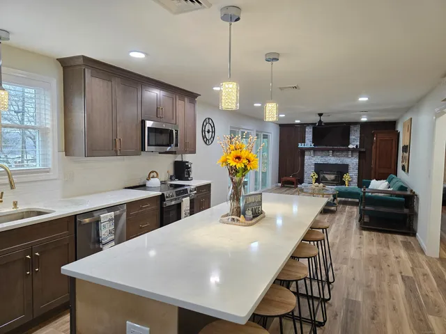 a kitchen with stainless steel appliances kitchen island granite countertop a sink a stove and cabinets