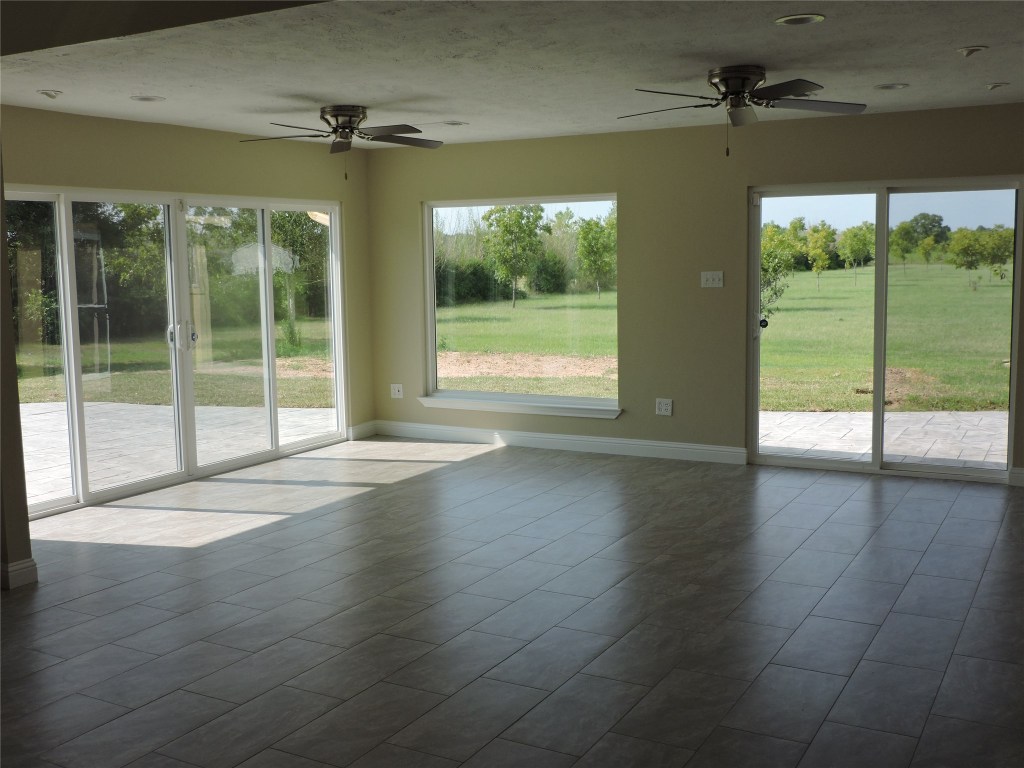 25730 Beckendorff Road Katy, TX 77493 - Photo 26 of 42 a view of an empty room with wooden floor and a floor to ceiling window