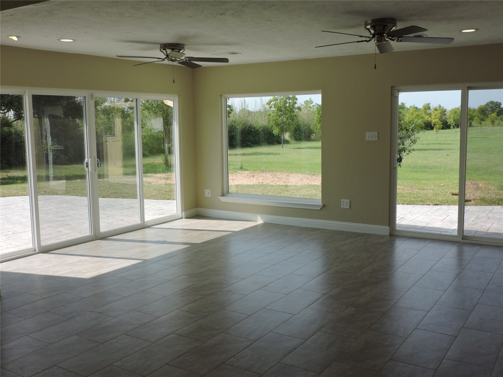 25730 Beckendorff Road Katy, TX 77493 - Photo 27 of 42 an empty room with wooden floor and windows
