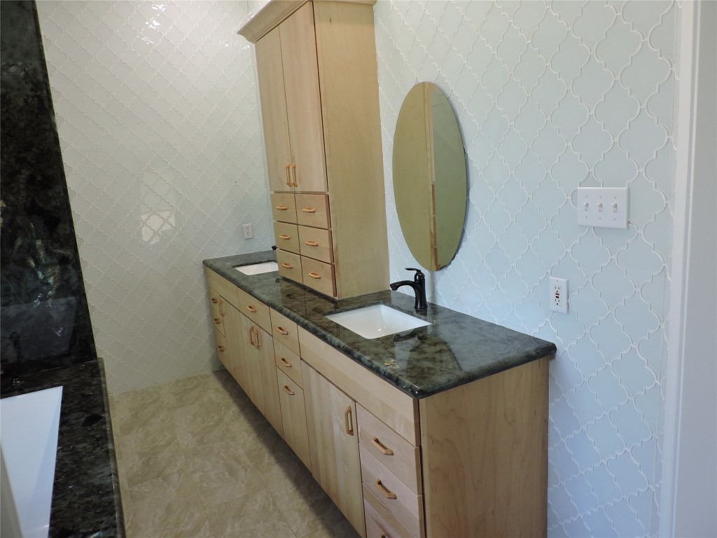 25730 Beckendorff Road Katy, TX 77493 - Photo 32 of 42 a bathroom with a granite countertop sink and a mirror