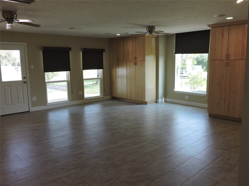25730 Beckendorff Road Katy, TX 77493 - Photo 9 of 42 an empty room with wooden floor and windows