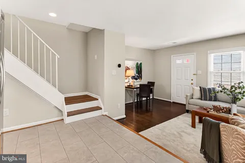 a living room with furniture a flat screen tv and kitchen view