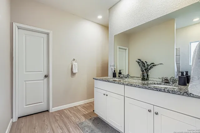 a bathroom with a granite countertop sink and a mirror