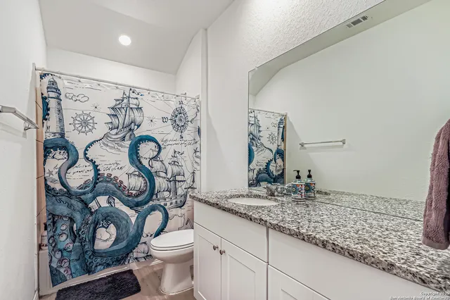 a bathroom with a toilet sink and mirror