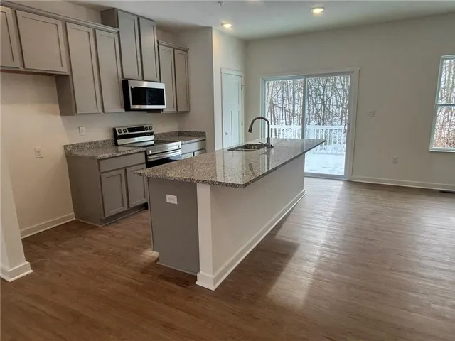 a kitchen with stainless steel appliances granite countertop a sink stove and microwave