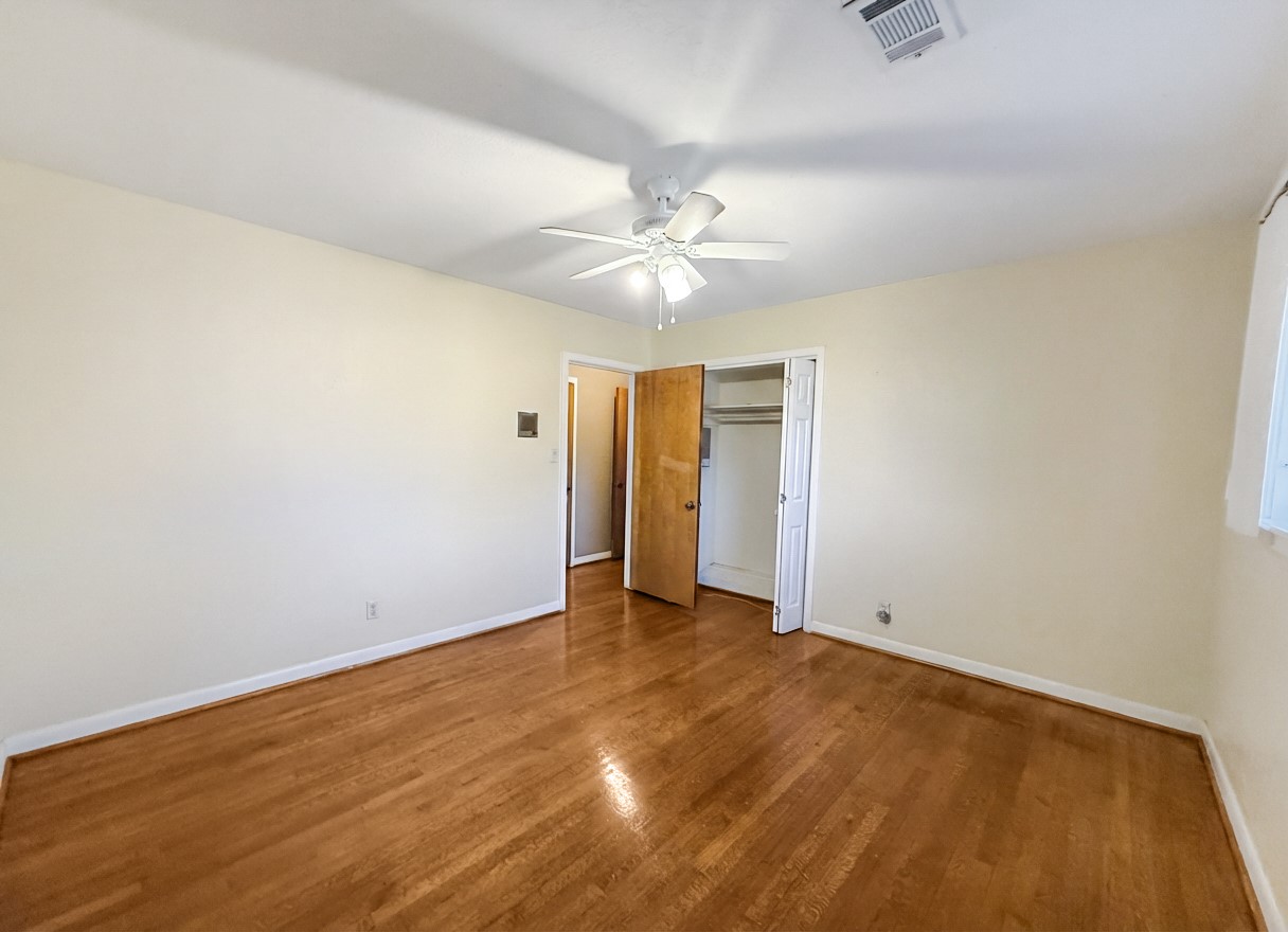 8219 Colgate Street Houston, TX 77061 - Photo 27 of 39 an empty room with a ceiling fan and wooden floor