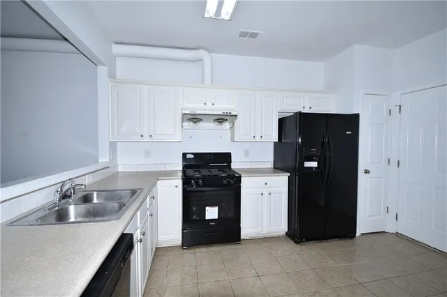 a kitchen with a refrigerator and a sink