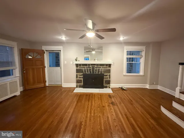 a view of an empty room with a fireplace and a window