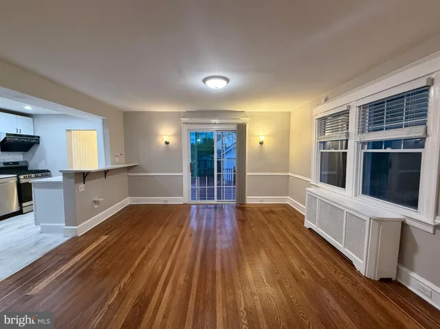 a view of a big room with wooden floor and windows