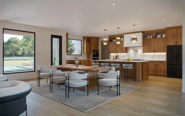 a living room with stainless steel appliances kitchen island granite countertop furniture and a large window