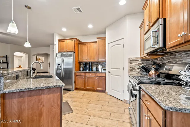 a kitchen with stainless steel appliances granite countertop a sink stove and refrigerator