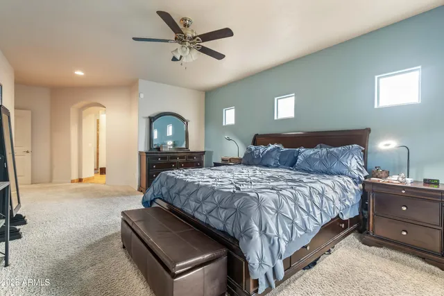 a spacious bedroom with a bed and a chandelier