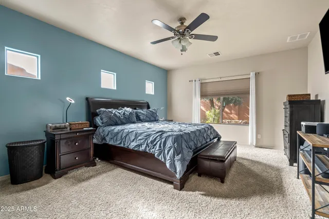 a spacious bedroom with a bed a couch and a chandelier
