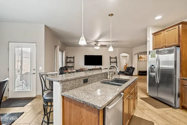 a kitchen with stainless steel appliances granite countertop a sink refrigerator and cabinets