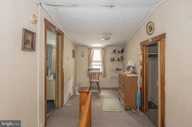 a view of a hallway with bathroom and mirror