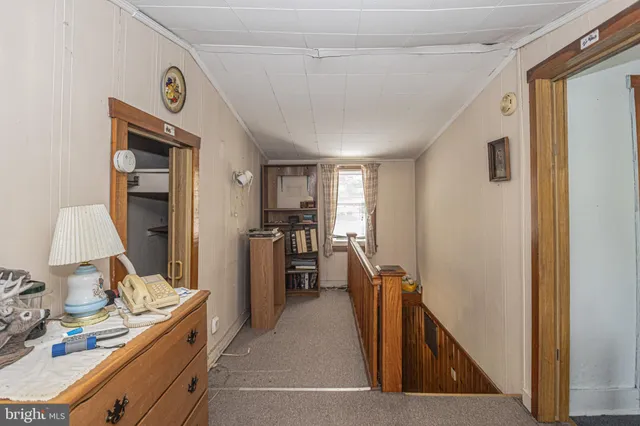 a view of a hallway and a livingroom with furniture