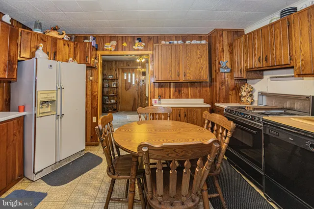 a dining table with chairs and a refrigerator