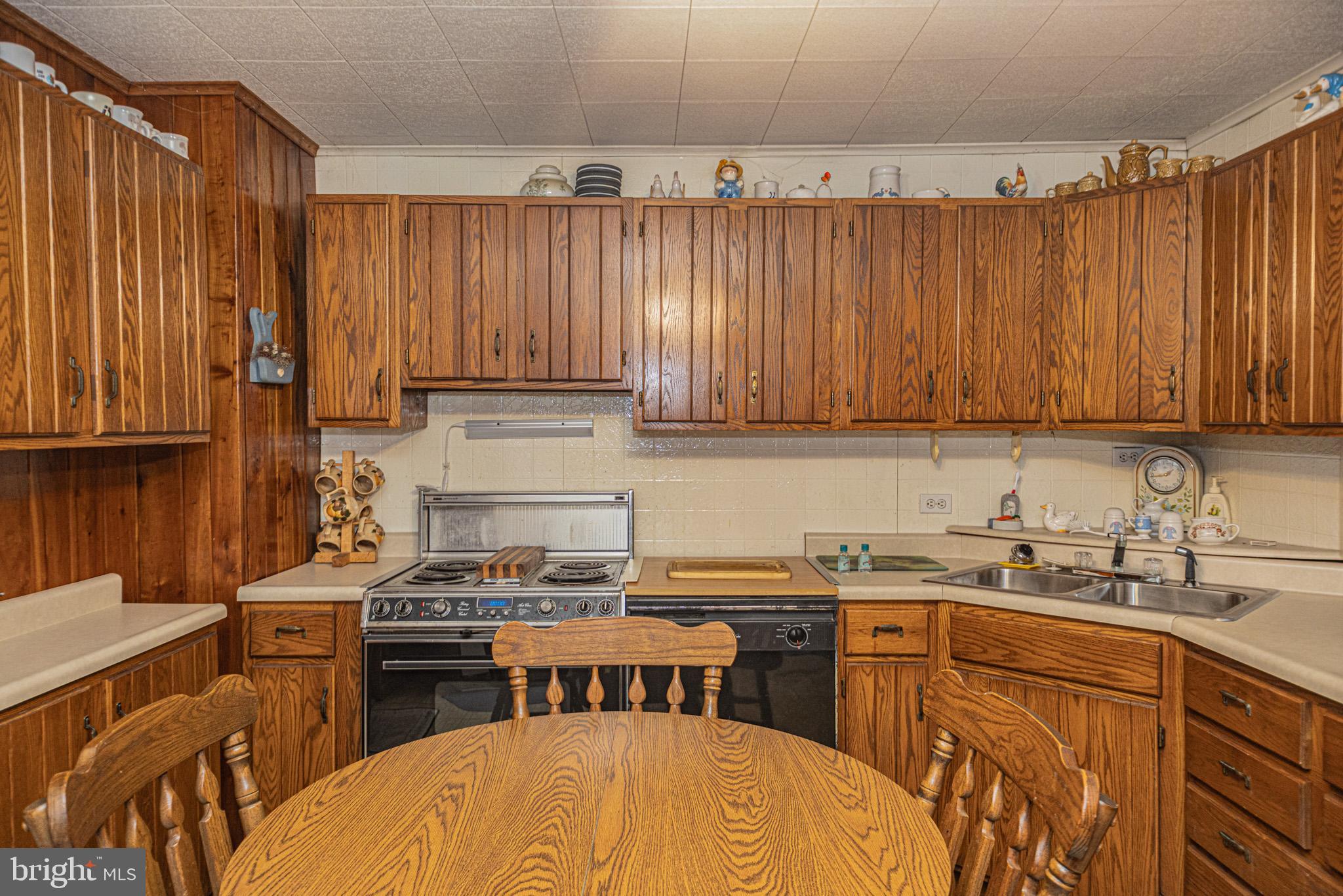 12376 Friendsville Road Friendsville, MD 21531 - Photo 19 of 37 a kitchen with stainless steel appliances a sink a stove a kitchen island and chairs