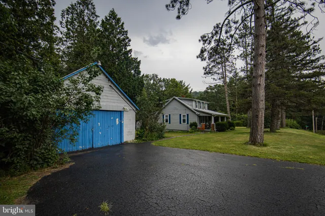 a view of a house with a yard and large trees