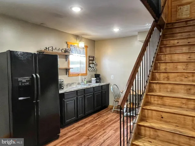 a kitchen with granite countertop a refrigerator and a sink