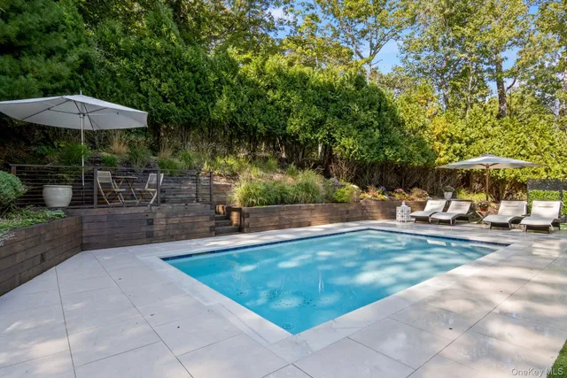 a view of a swimming pool with a yard and sitting area