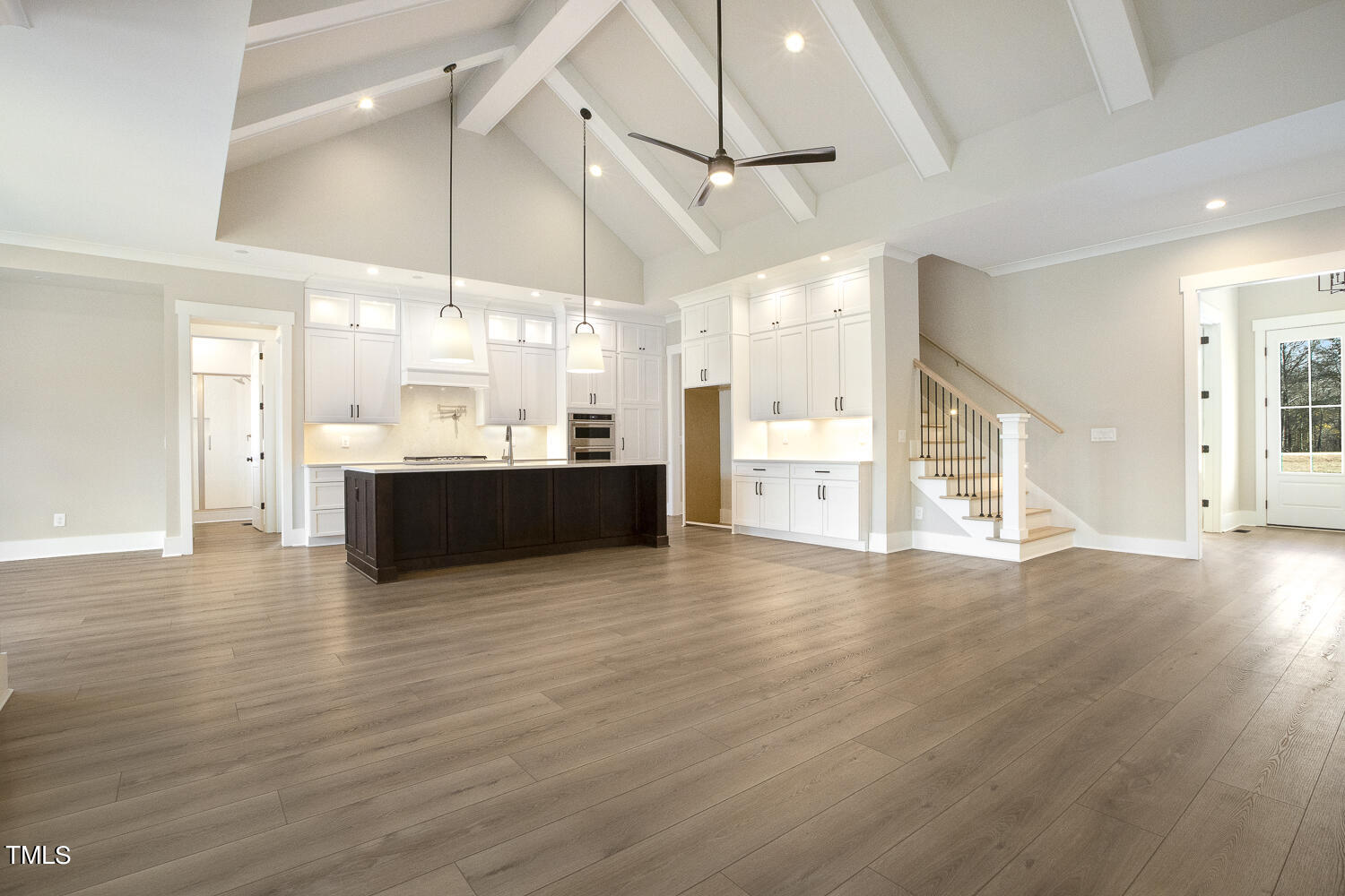 593 Pope Lake Road Angier, NC 27501 - Photo 17 of 48 an empty room with wooden floor and kitchen view