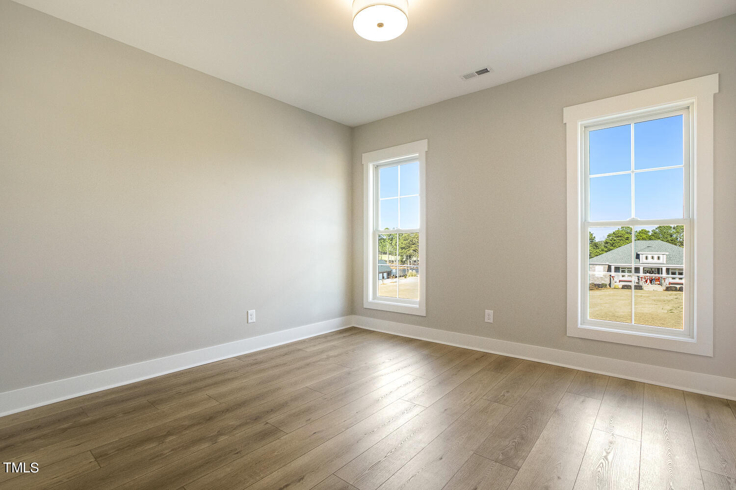 593 Pope Lake Road Angier, NC 27501 - Photo 41 of 48 an empty room with wooden floor and windows