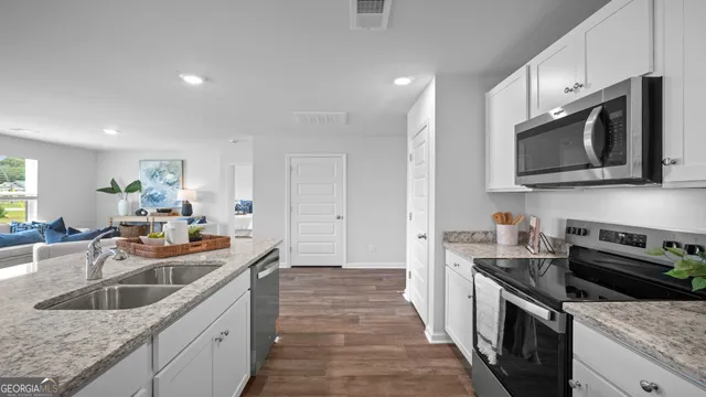 a kitchen with a sink and wooden floor