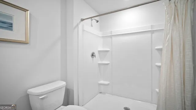 a bedroom with a bed and painting on the wall