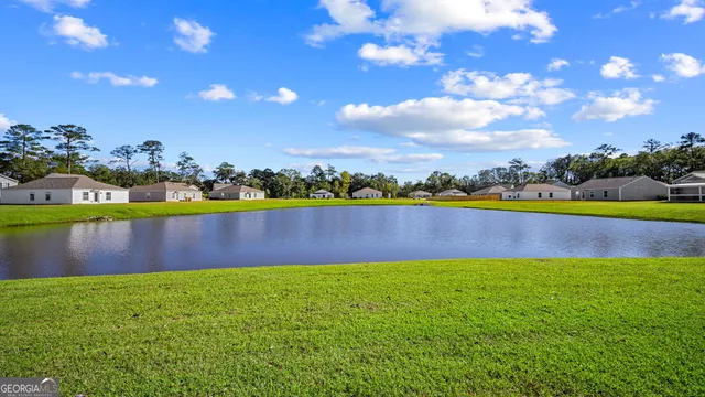 a view of a swimming pool with a yard and plants