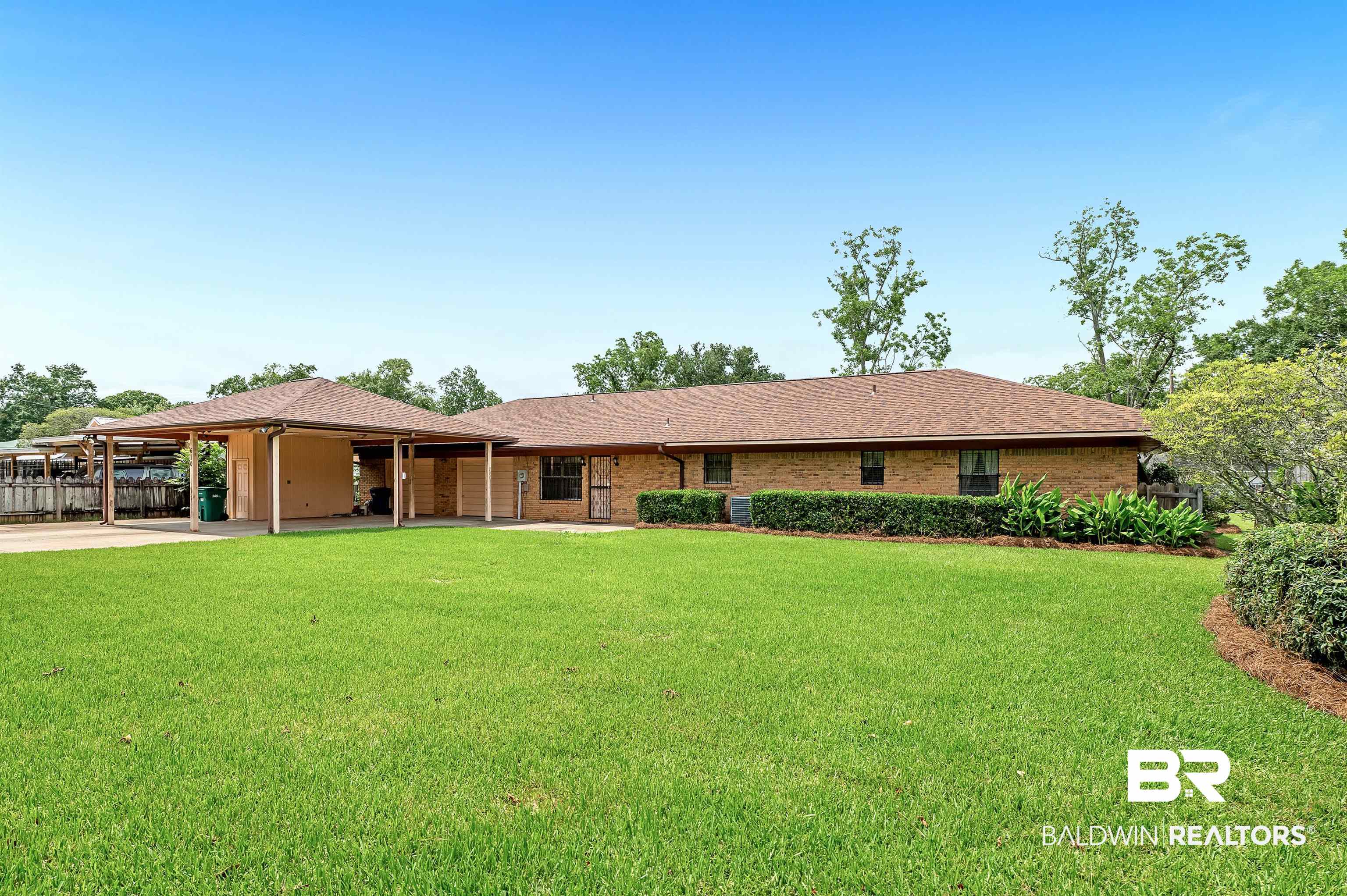 610 East Walker Avenue Foley, AL 36535 - Photo 7 of 38 View of front facade featuring an attached carport, concrete driveway, and brick siding