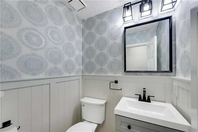 a bathroom with a toilet a sink and mirror