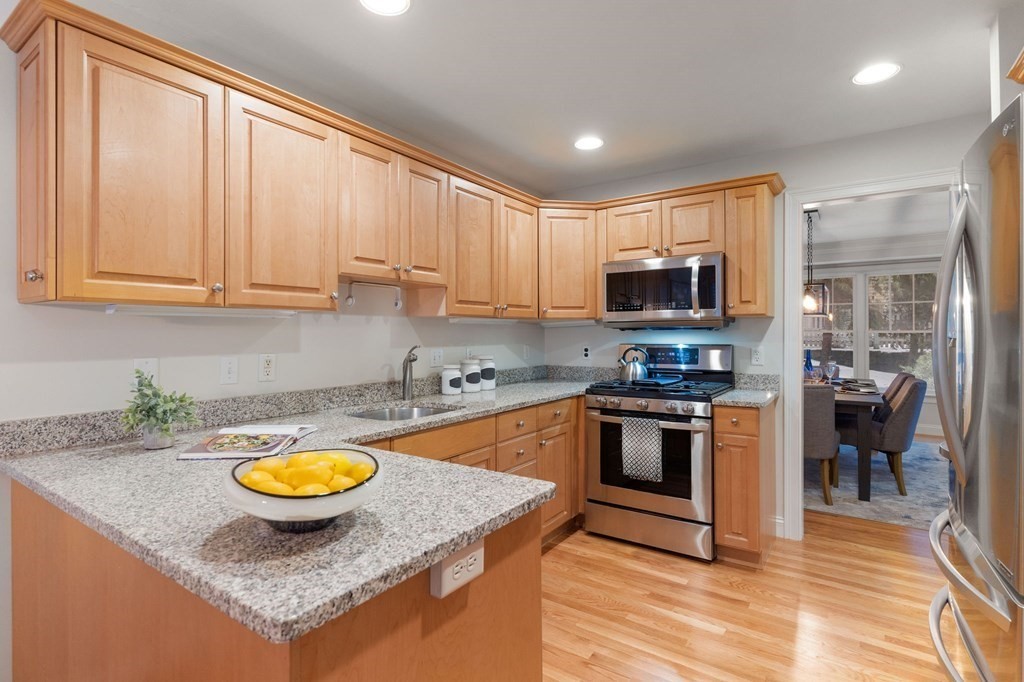11 Meadowbrook Road, Unit 11 Brookline, MA 02467 - Photo 6 of 42 a kitchen with a sink a stove a microwave and cabinets