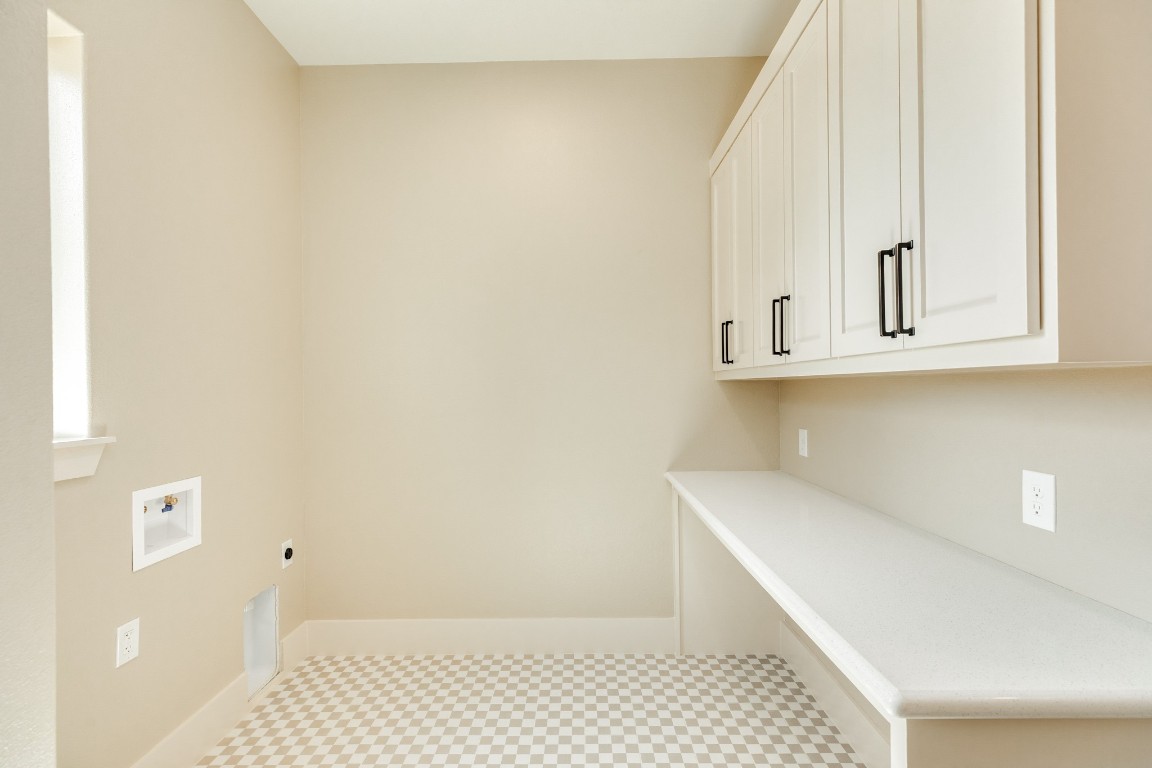 1737 Flintlock Court Angleton, TX 77515 - Photo 23 of 47 The utility room has modern checkered flooring elevating the space and a large folding table for convience while doing laundry.
