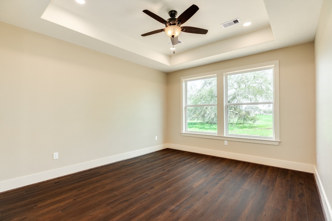 1737 Flintlock Court Angleton, TX 77515 - Photo 24 of 47 The primary bedroom offers trayed ceilings and views of the mature trees that circle the home providing the most beautiful views from almost every room of the house.