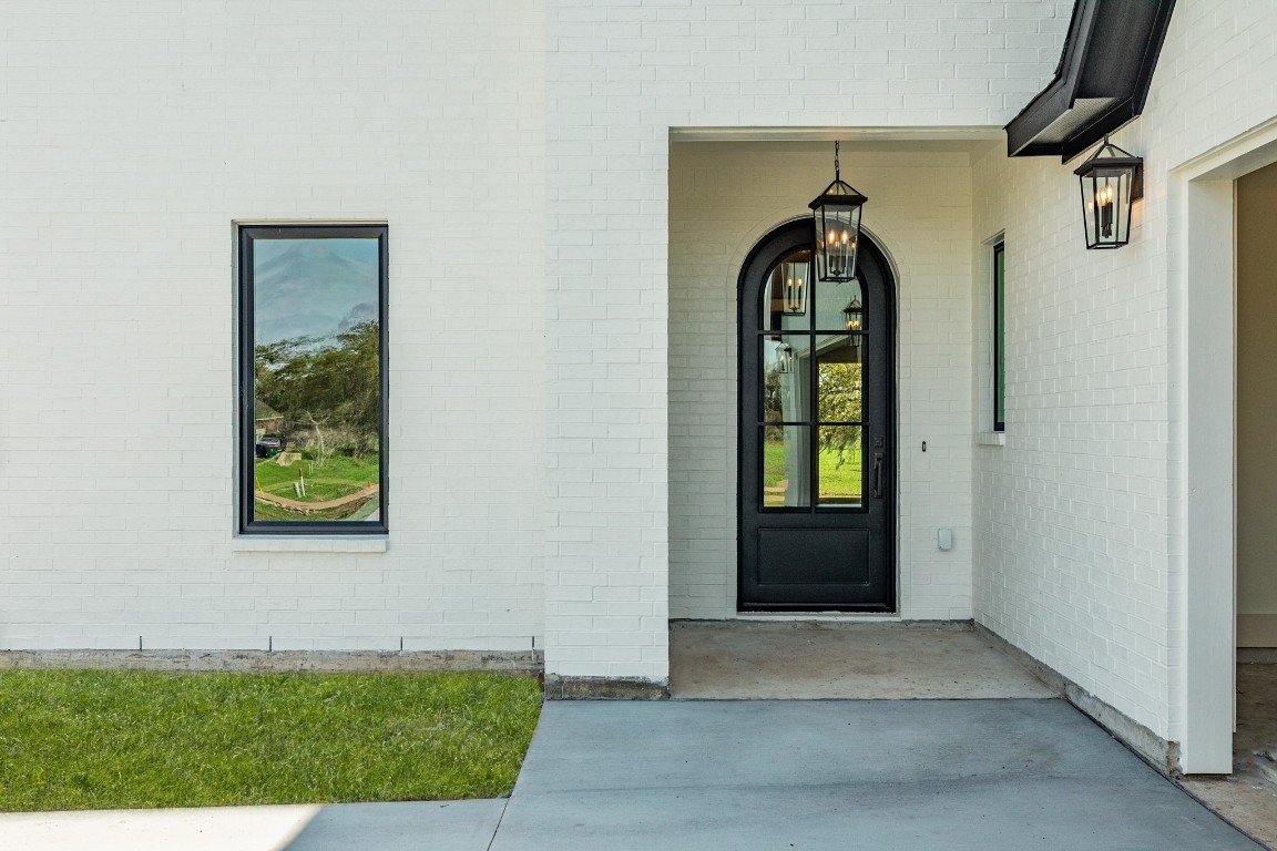 1737 Flintlock Court Angleton, TX 77515 - Photo 8 of 47 Iron black arch door to elevate the front entry of the home. Paired with black windows and black trim this home offers true modern elegrance.