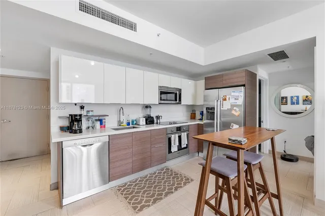 a kitchen with stainless steel appliances kitchen island granite countertop a sink and cabinets