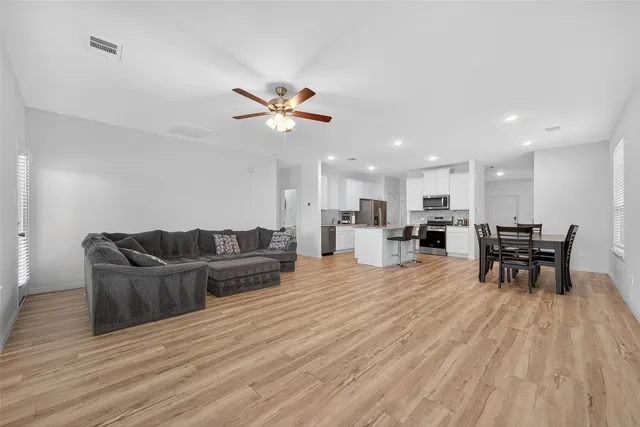 a living room with furniture and a wooden floor