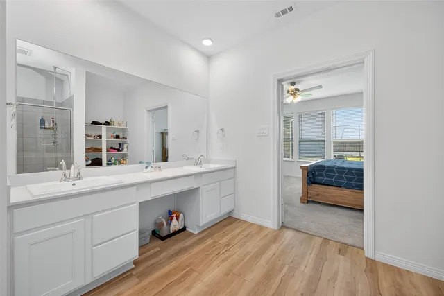 a en suite bathroom with a double vanity sink and a mirror