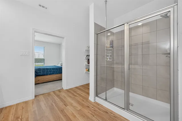 a bathroom with a glass shower door and a sink