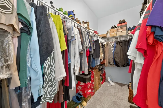 a view of walk in closet with clothes