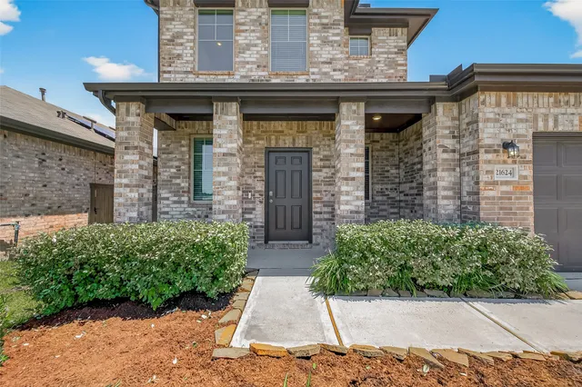 a view of a brick house with potted plants