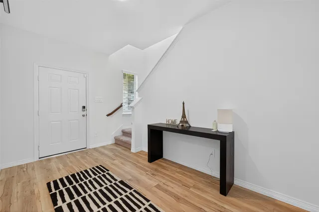 a view of entryway and hall with wooden floor