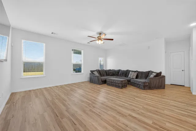 a living room with furniture and a ceiling fan