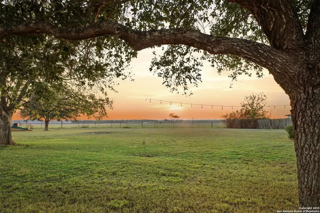 a view of a ocean with a yard and wooden fence