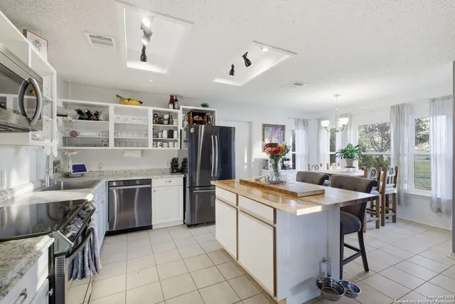a kitchen with stainless steel appliances granite countertop a sink stove oven and refrigerator